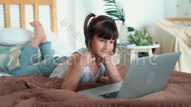 小女孩躺在床上，用笔记本电脑，按键盘上的按钮，慢动作